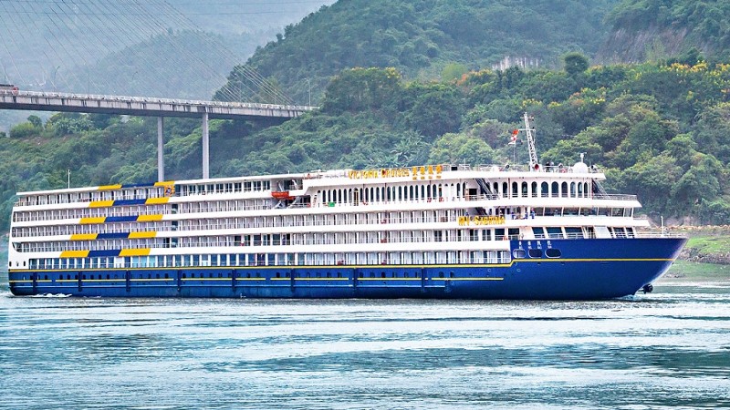 et stort cruiseskip p� Yangtze elven i fargene hvitt, bl�tt og litt gult