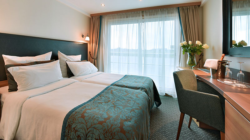 Skrivebord og dobbeltseng p� standardlugar. Utsikt gjennom store vinduer.