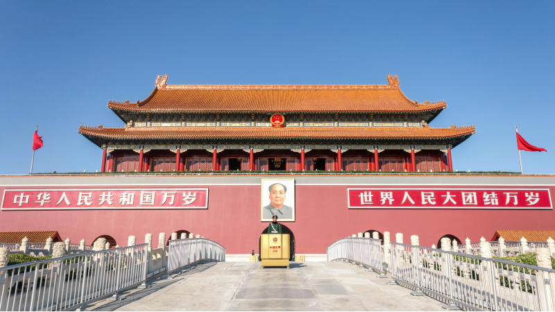  r�d bygning med bilde av Mao med kinesiske flagg rundt og en hvit bro