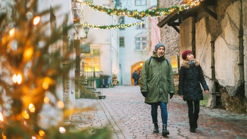 To personer spaserer i en brosteinsgate i Gamlebyen