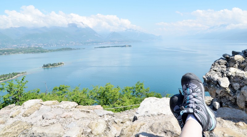 en person med bilde av sine fjellsko og utsikten utover Gardasj�en