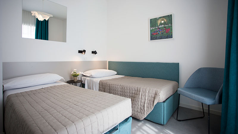 Soverom med to separate senger. Speil og bilde p� veggen.